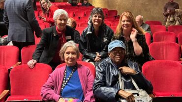 group of people sitting in theater audience