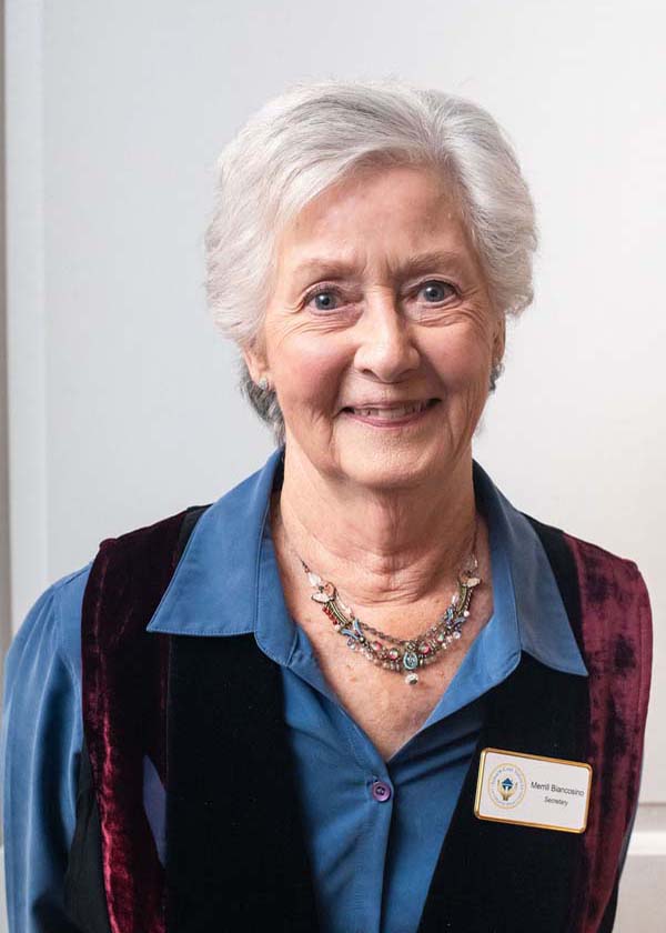 female wearing blue shirt and maroon vest