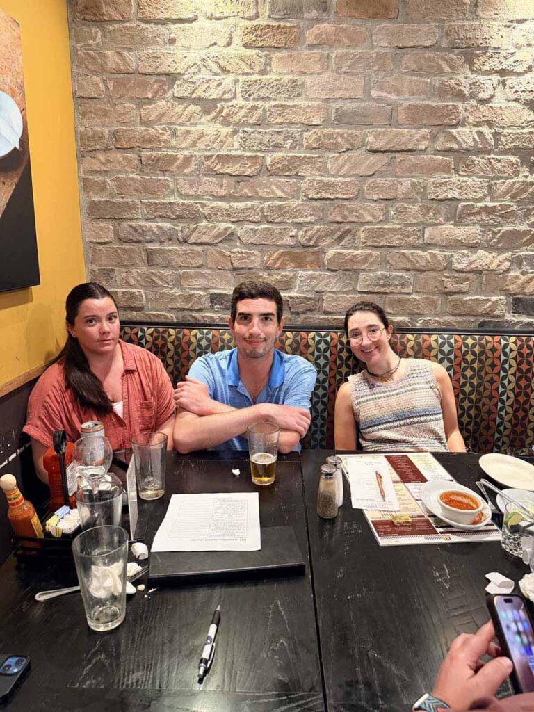 3 people sitting at a table in a restaurant